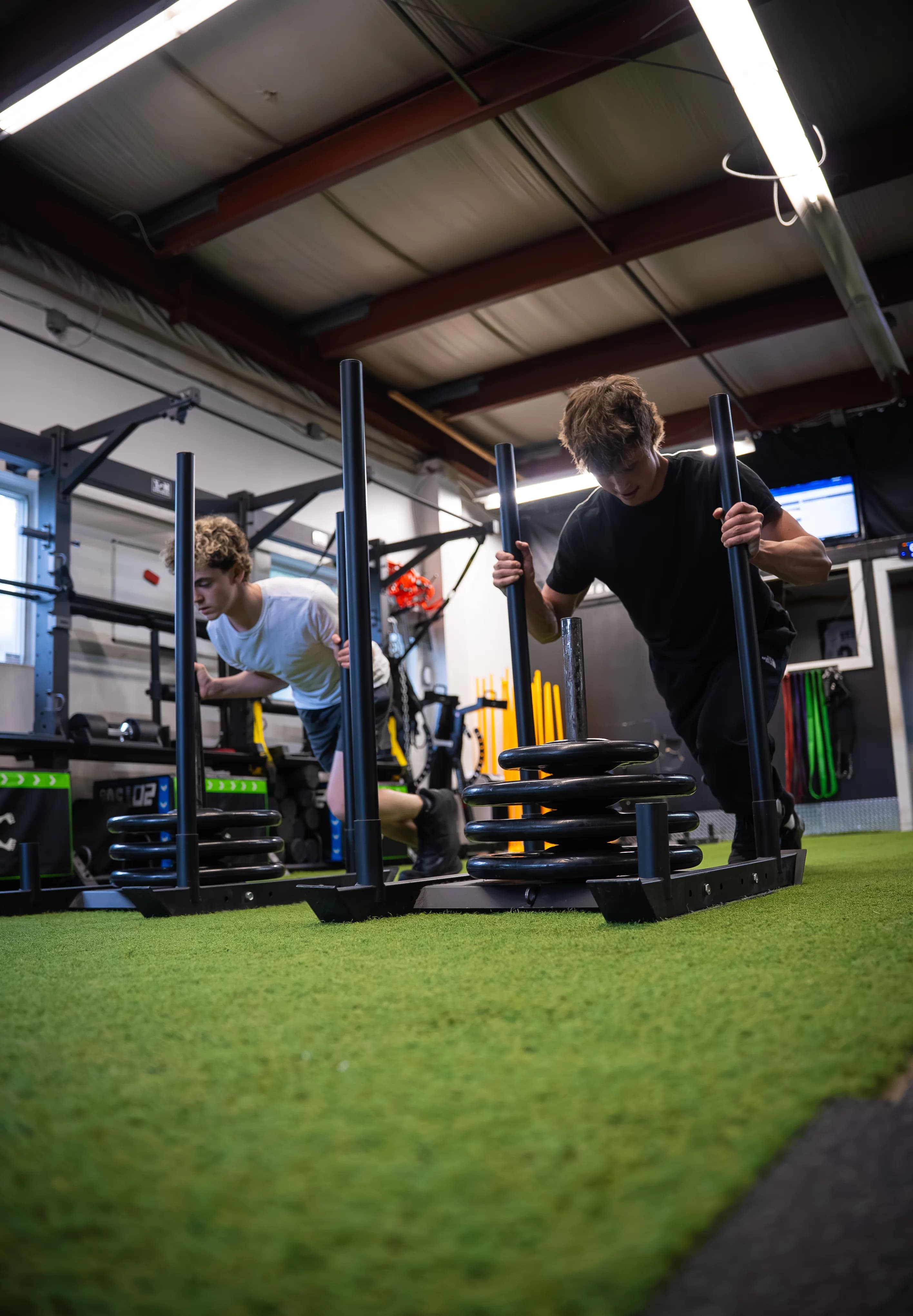 Two athletes pushing sleds at Shaw Hockey Performance